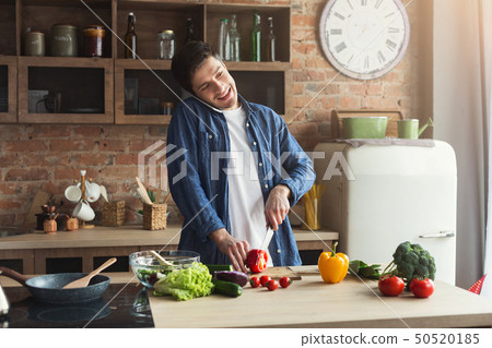 Happy man preparing healthy food in the home kitchen 50520185