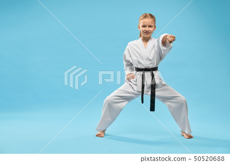 Female teenager standing in stance and punching in studio 50520688