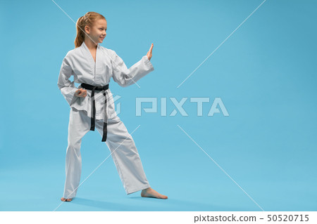 Side view of smiling girl in white kimono training karate 50520715
