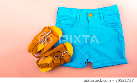 Sandals and shortson a pink background.  Sandals and shortson a pink background.  50521737