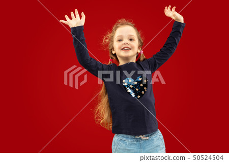 Beautiful emotional little girl isolated on red background 50524504
