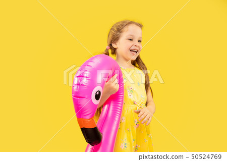 Beautiful emotional little girl isolated on yellow background Beautiful emotional little girl isolated on yellow background 50524769