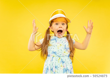 Beautiful emotional little girl isolated on yellow background 50524873