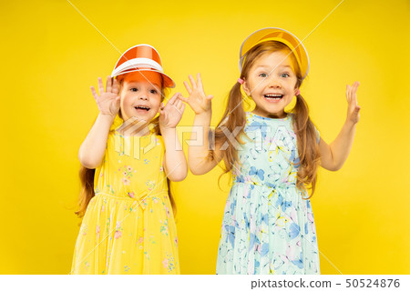 Beautiful emotional little girls isolated on yellow background 50524876