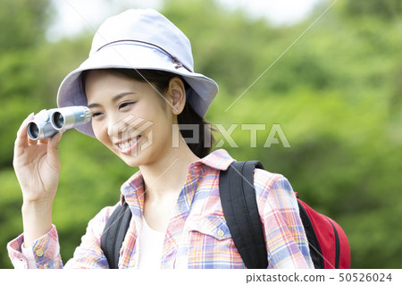 A woman looking into binoculars A woman looking into binoculars 50526024
