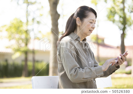 Senior woman operating a smartphone 50526380