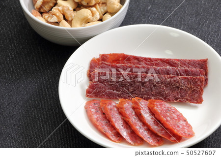 各種小吃。乾香腸和牛肉乾。在照片的背面,混合堅果。 各種小吃。乾香腸和牛肉乾。在照片的背面,混合堅果。 50527607
