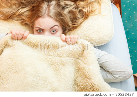 Woman waking up under wool woolen blanket. Woman waking up under wool woolen blanket. 50528457