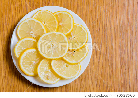 木の背景に新鮮な黄色いレモンスライス、 ビタミンC、栄養価の高いレモン 木の背景に新鮮な黄色いレモンスライス、 ビタミンC、栄養価の高いレモン 50528569
