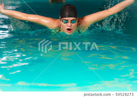 Woman athlete swimming butterfly stroke in pool. Woman athlete swimming butterfly stroke in pool. 50529273