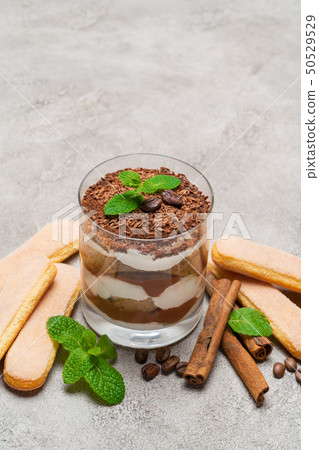 Classic tiramisu dessert in a glass and savoiardi cookies on concrete background 50529529