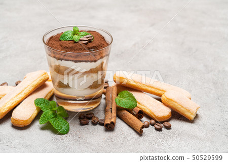 Classic tiramisu dessert in a glass and savoiardi cookies on concrete background 50529599