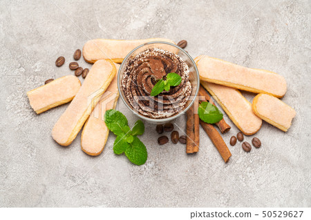 Classic tiramisu dessert in a glass and savoiardi cookies on concrete background 50529627