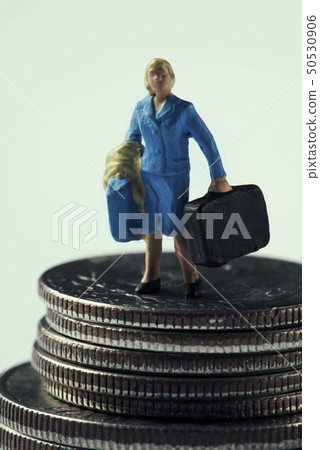 miniature woman with a suitcase on dollar coins 50530906
