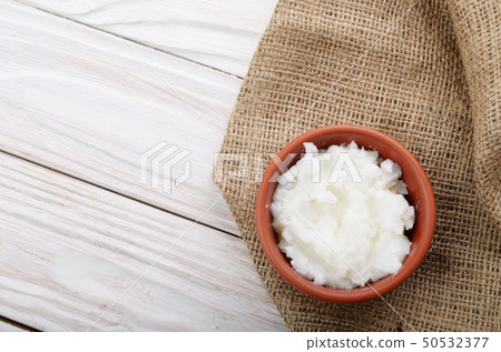Flat lay Coconut oil in brown clay bowl on hemp Flat lay Coconut oil in brown clay bowl on hemp 50532377