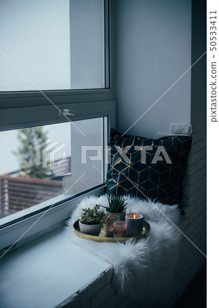 Cozy real home decoration, burning candles on golden tray with pillow on white faux fur on Cozy real home decoration, burning candles on golden tray with pillow on white faux fur on 50533411