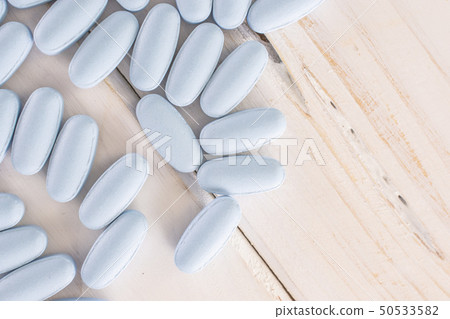 Blue medical pills on grey wood 50533582