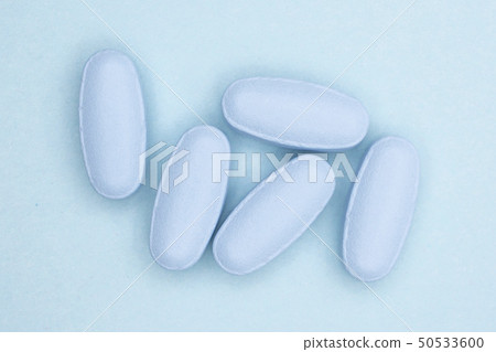 Blue medical pills on light blue 50533600