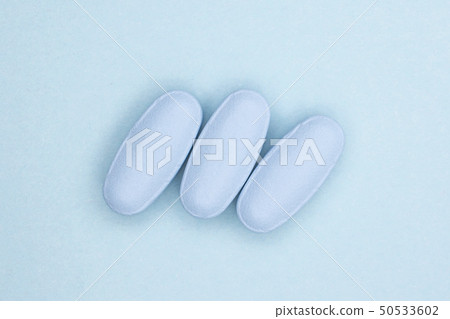 Blue medical pills on light blue Blue medical pills on light blue 50533602