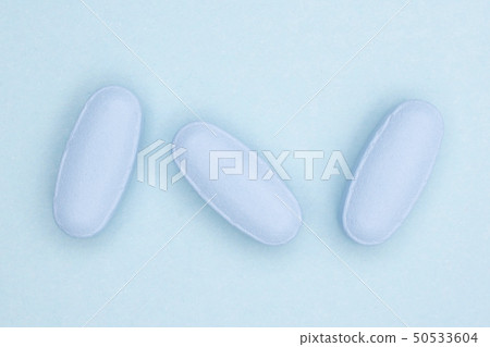 Blue medical pills on light blue Blue medical pills on light blue 50533604