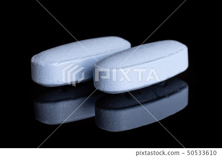 Blue medical pills isolated on black glass 50533610