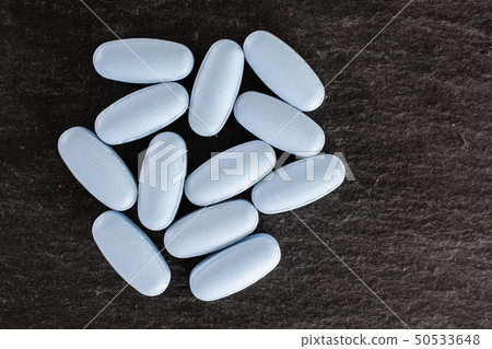 Blue medical pills on grey stone Blue medical pills on grey stone 50533648