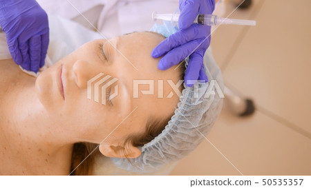 The cosmetologist makes injections, anti-aging procedures for tightening and smoothing wrinkles on 50535357