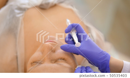 The cosmetologist makes injections, anti-aging procedures for tightening and smoothing wrinkles on 50535403