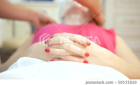 The concept of a beautician. beautician applies the film on the woman's face. anesthesia before the 50535820