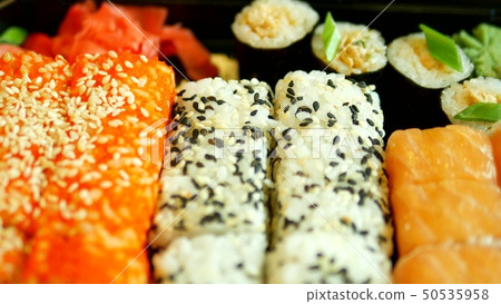 close-up. someone takes sushi with chopsticks, rolls. 50535958