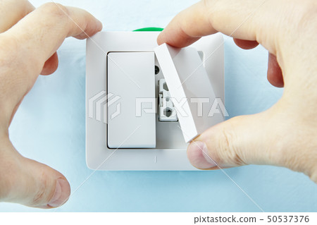 Worker mounts new push button. Worker mounts new push button. 50537376