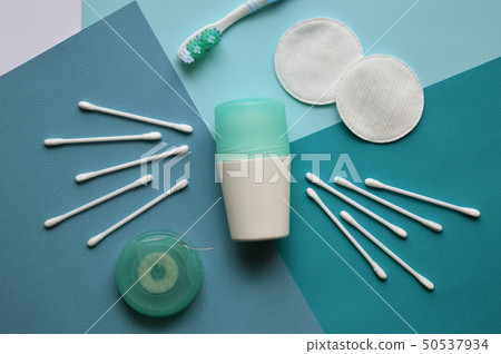 A deodorant, cotton pads for face and buds for ears, brushtooth and dental floss on blue background 50537934