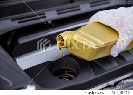 pouring engine oil into a car engine 50538740