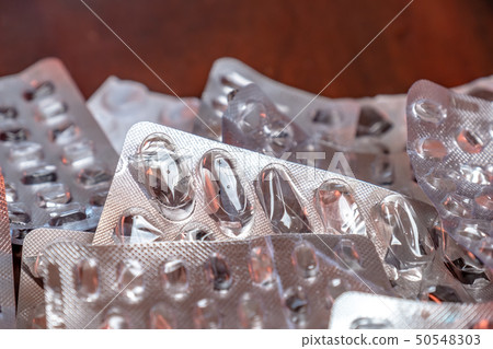 Empty blister packaging of medicine pills on wooden table 50548303