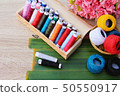 Colorful thread for sewing on wood background 50550917