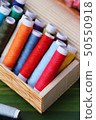 Colorful thread for sewing on wood background 50550918