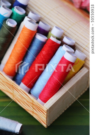 Colorful thread for sewing on wood background 50550918