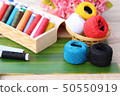Colorful thread for sewing on wood background 50550919