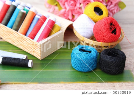 Colorful thread for sewing on wood background 50550919