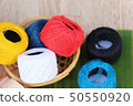 Colorful thread for sewing on wood background 50550920