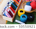 Colorful thread for sewing on wood background 50550921