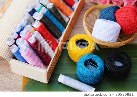 Colorful thread for sewing on wood background Colorful thread for sewing on wood background 50550921