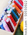 Colorful thread for sewing on wood background 50550922