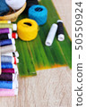 Colorful thread for sewing on wood background 50550924