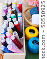 Colorful thread for sewing on wood background 50550925