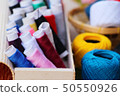 Colorful thread for sewing on wood background 50550926