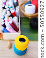 Colorful thread for sewing on wood background 50550927