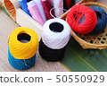 Colorful thread for sewing on wood background 50550929