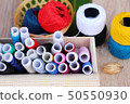 Colorful thread for sewing on wood background 50550930