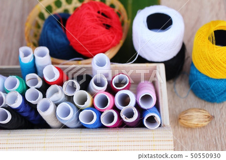 Colorful thread for sewing on wood background Colorful thread for sewing on wood background 50550930
